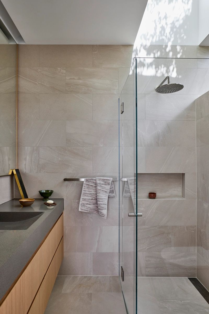 Stone tiled bathroom with a walk in shower and timber vanity