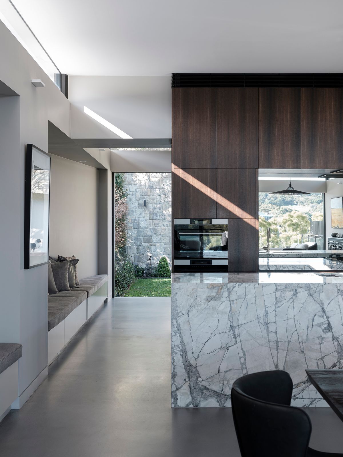 Kitchen at Shellbank House with a marble island, timber joinery and a window seat