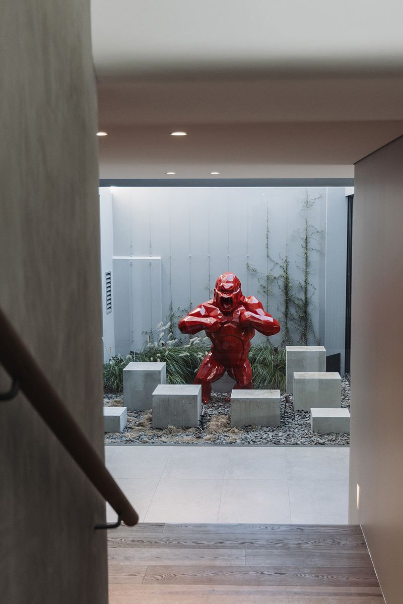Red gorilla sculpture in a courtyard, seen from the stair