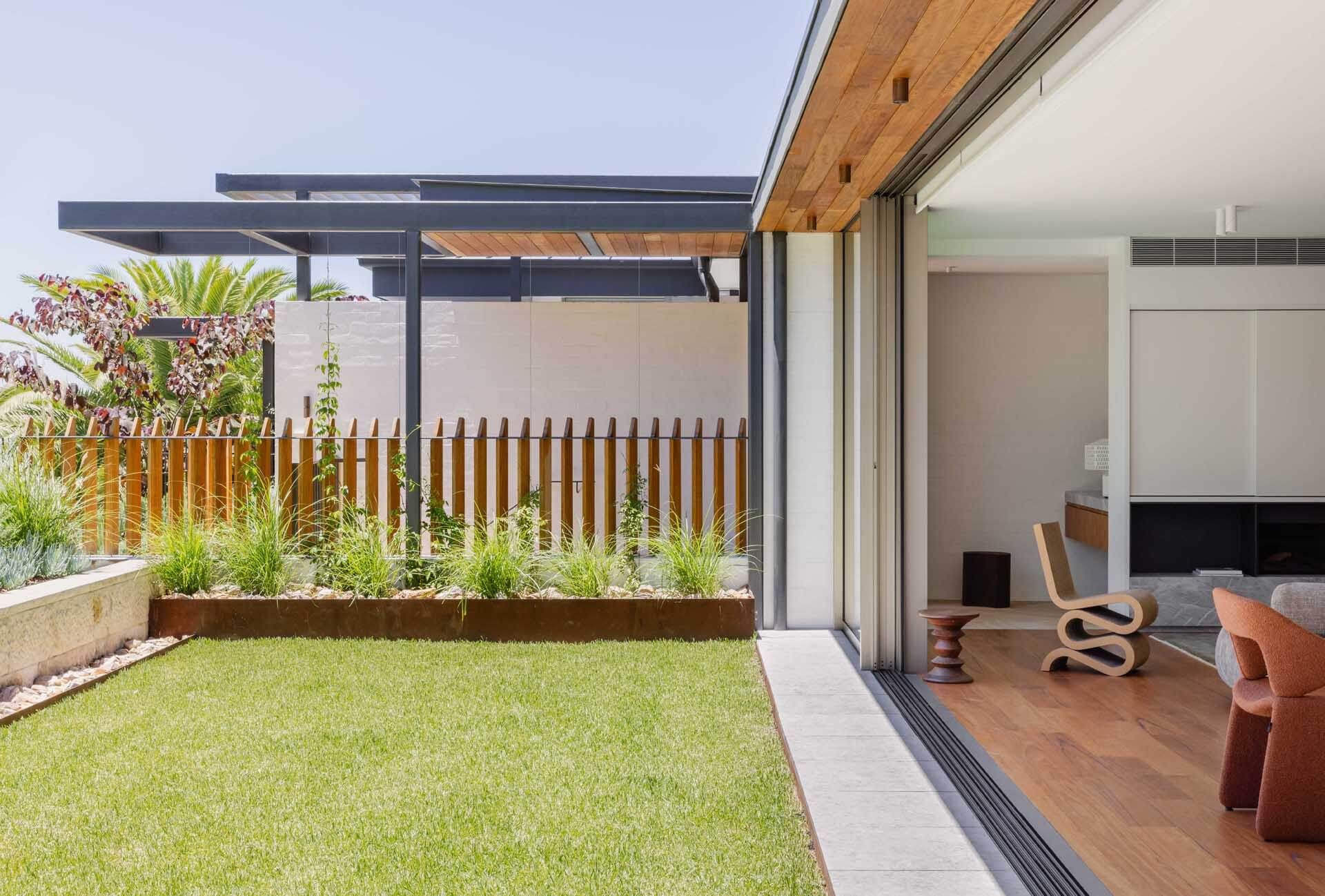 Lawn and timber fence beside the living room at Casa Risata