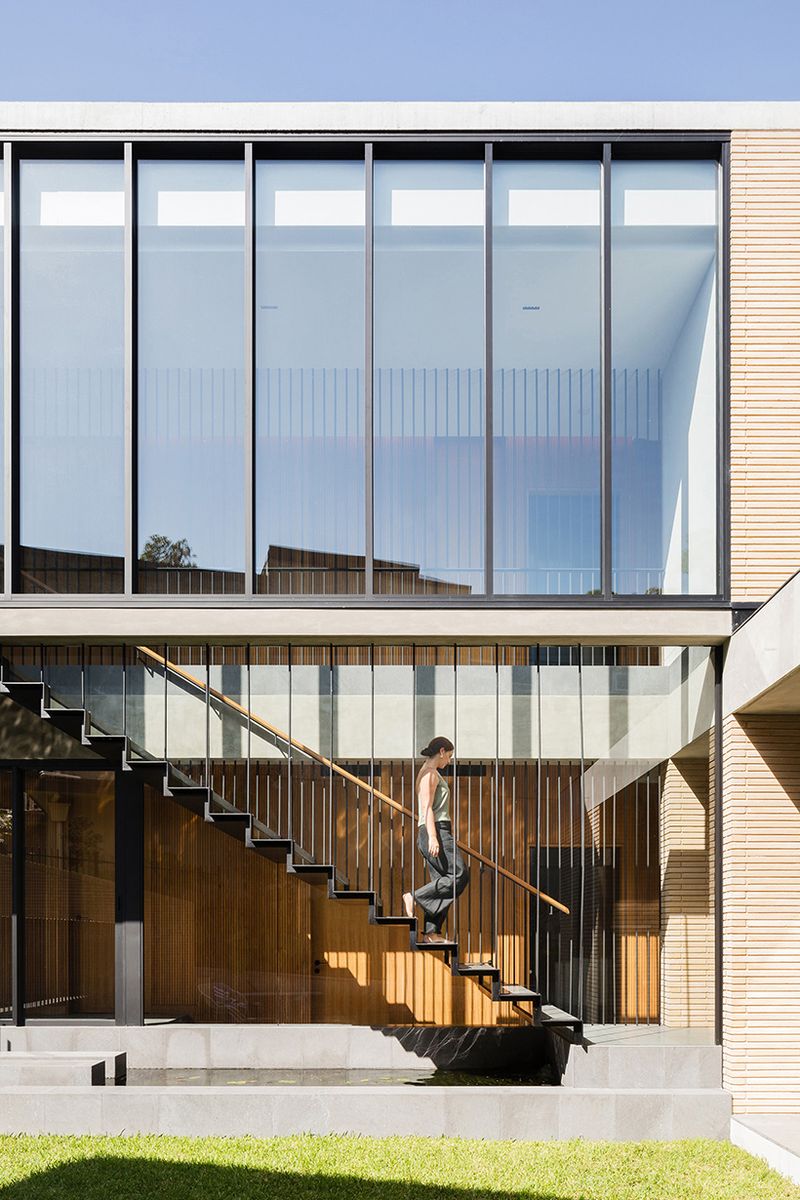 Balmoral House upper storey of glass and steel battens, a woman on the open stair below