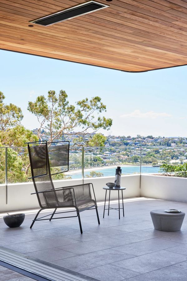 Cobbittee House terrace with a timber ceiling and wire chairs, looking over Mosman to the harbour