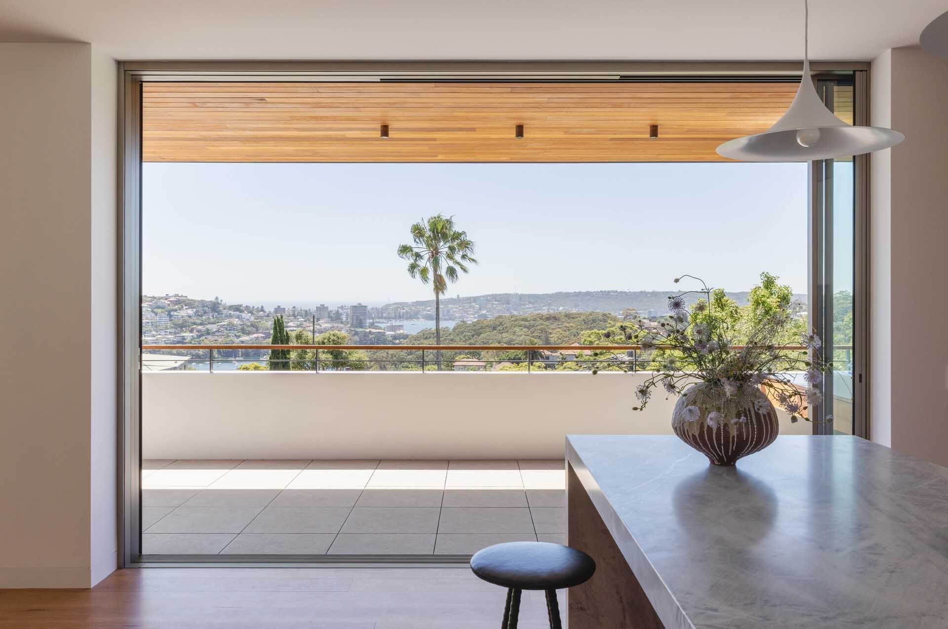 Kitchen window opening to a balcony with a view over the rooftops to the water