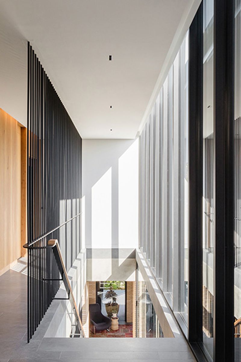 Upper level walkway with steel battens looking down to the living room