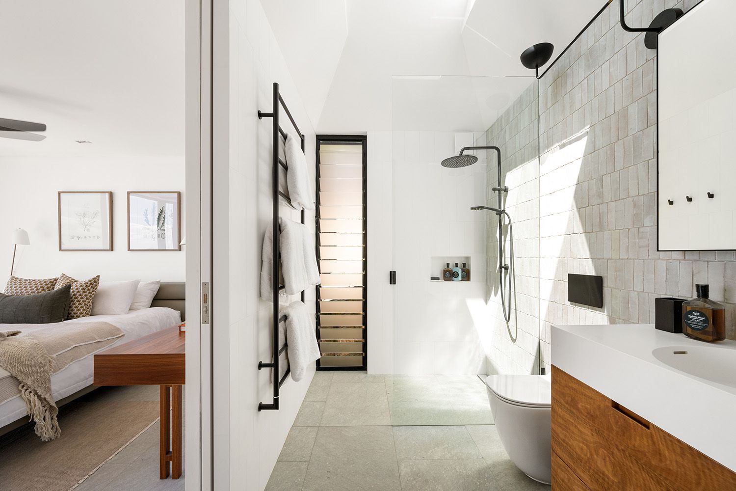 Bathroom with a freestanding bath and shower beside a bedroom