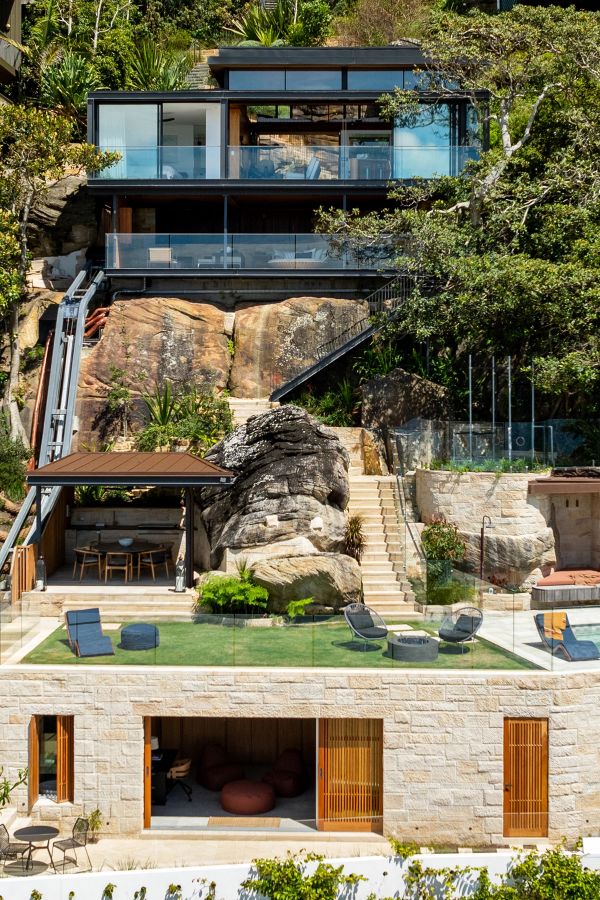 Swell and High Swell stepping down a bush hillside at Palm Beach, glass pavilions above a sandstone pool terrace