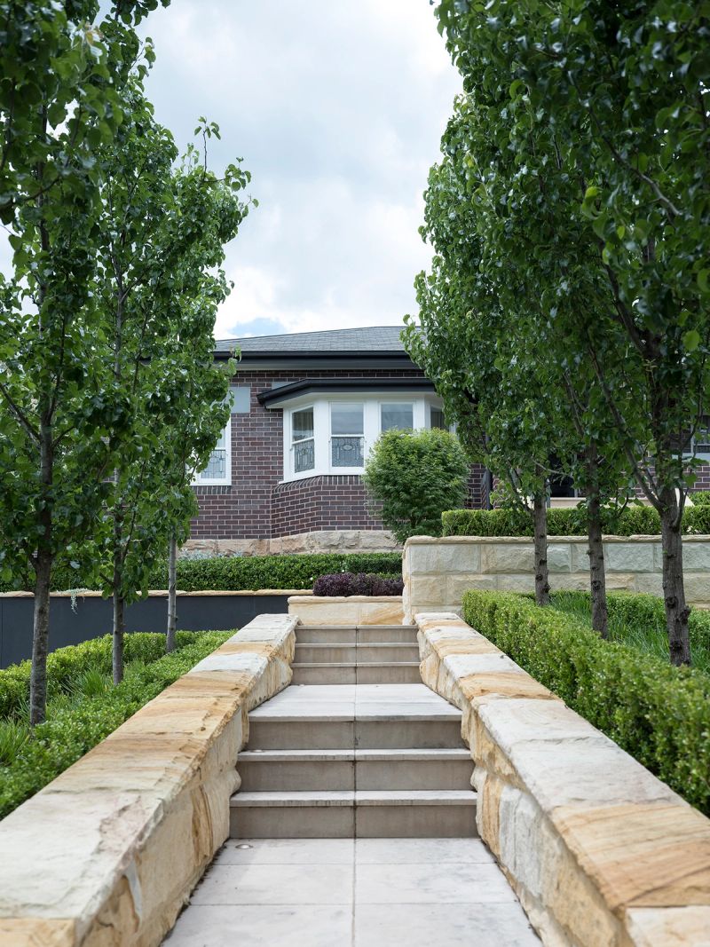 Sandstone steps and clipped hedges leading to Sussex House