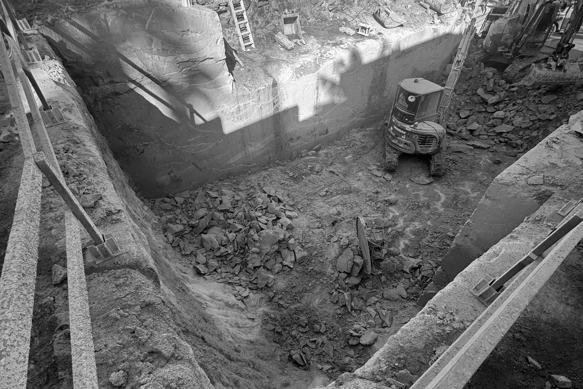 The basement excavation at Tamarama, an excavator at the far wall of the rock cut