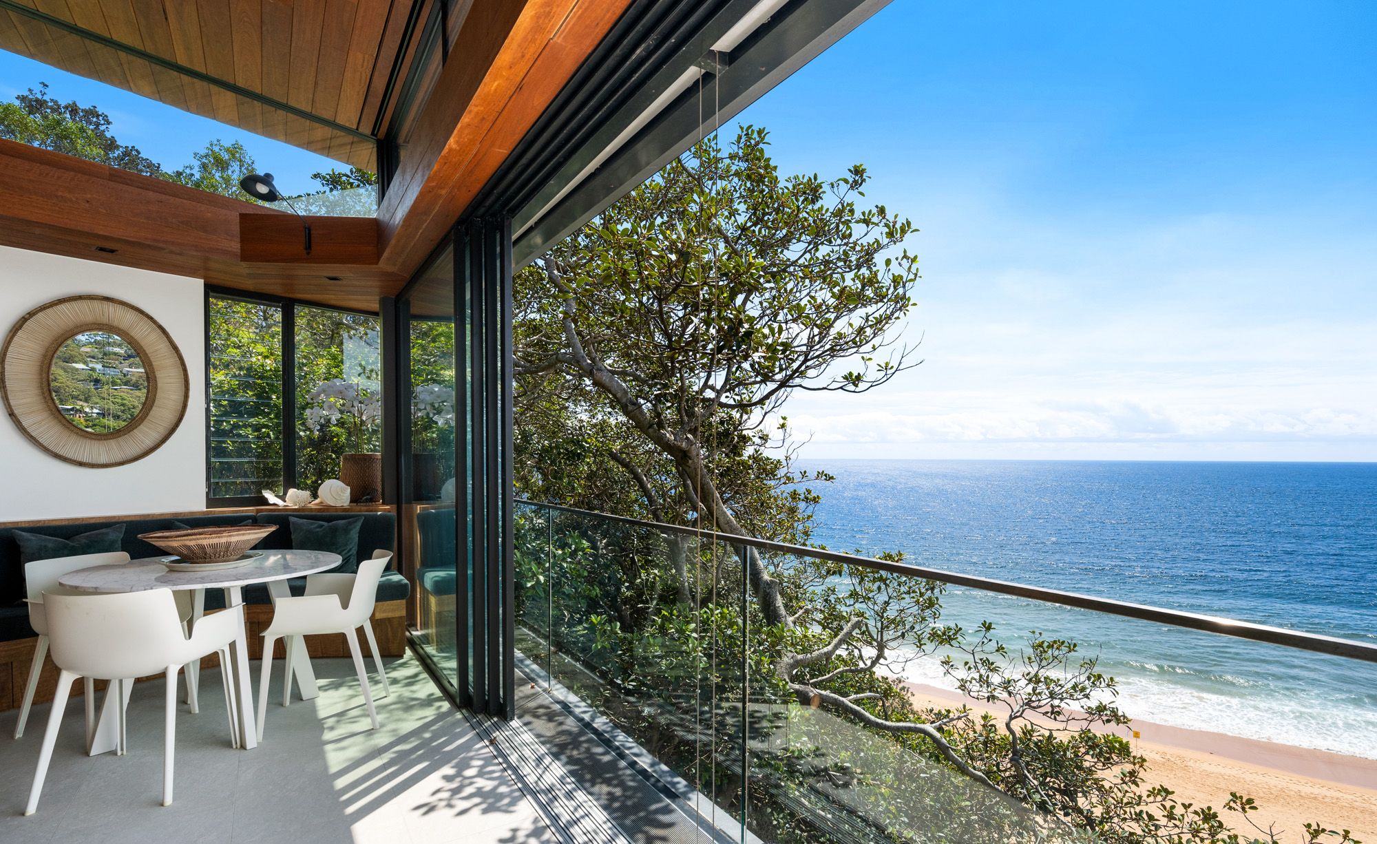 Dining area opening onto a balcony above the beach