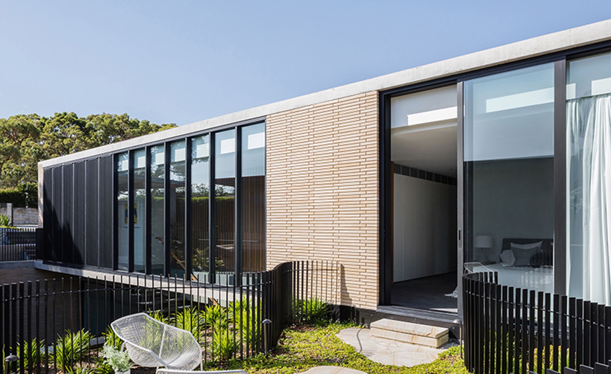 Balmoral House from the garden, with a bedroom opening onto a paved terrace