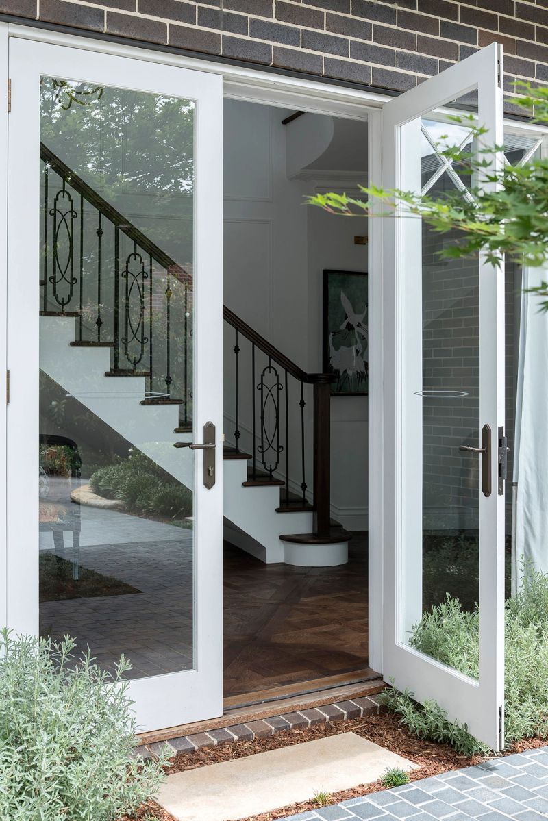 Open French doors onto a brick paved garden path