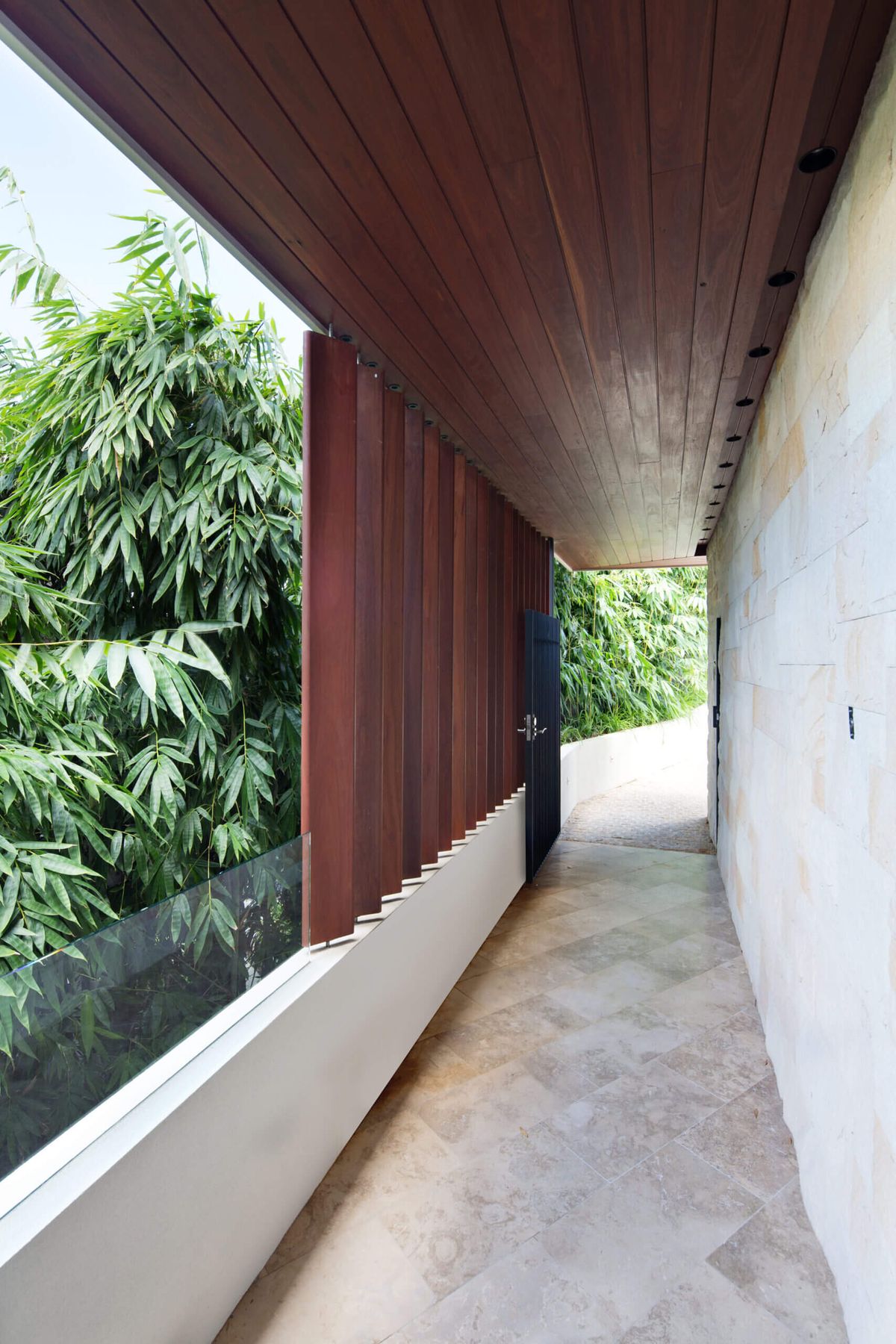 Sandstone walkway beside a timber batten screen, with bamboo alongside