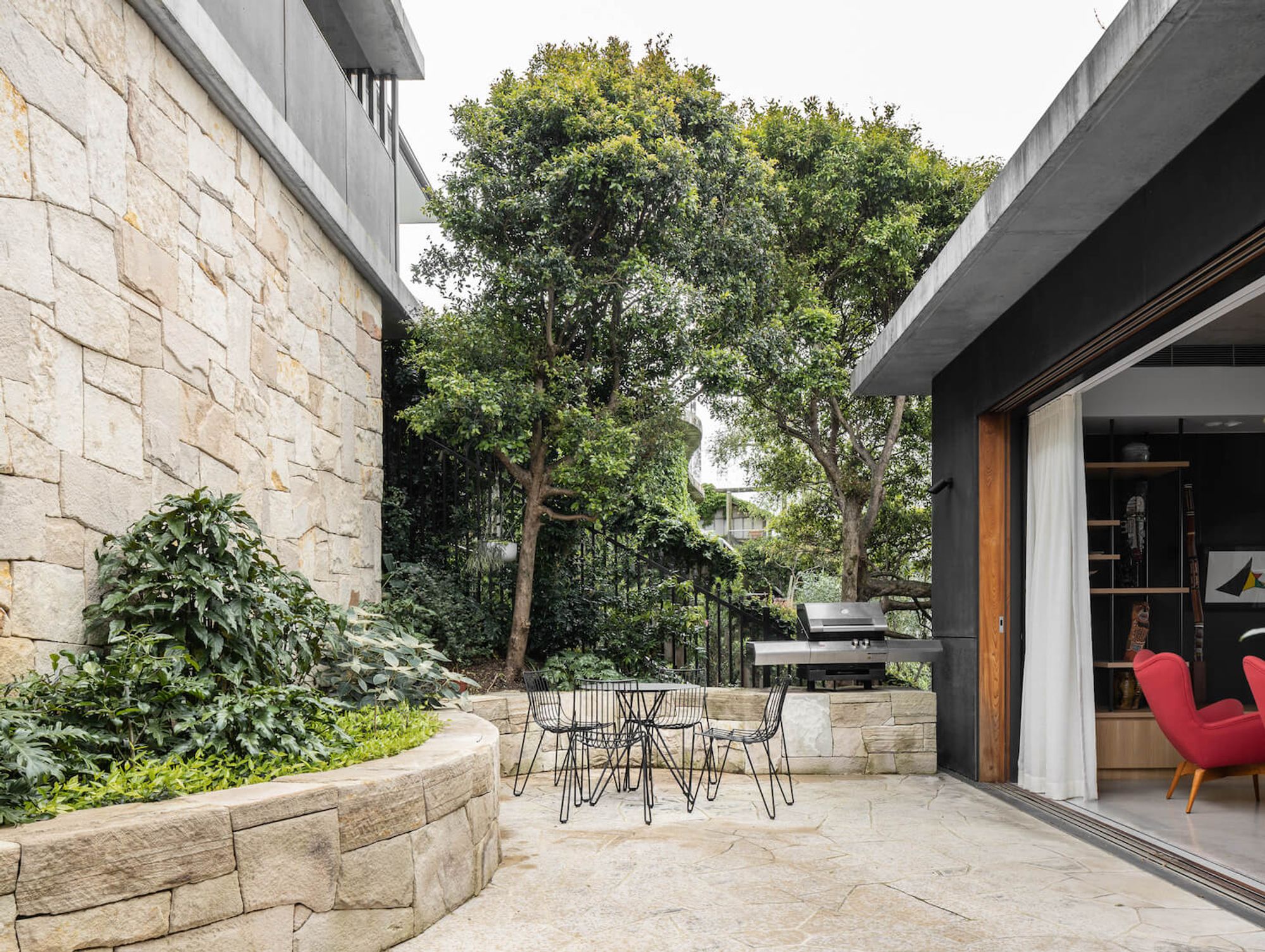 Sandstone courtyard with an outdoor table beneath a tree