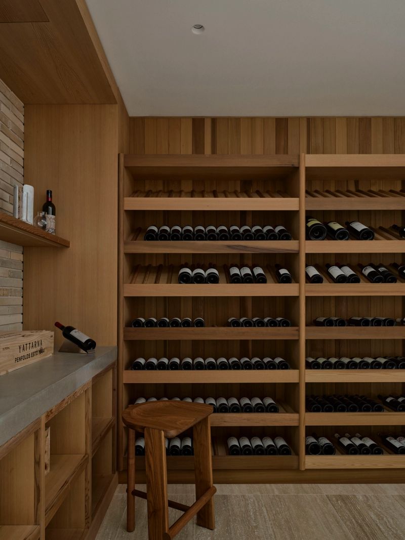 Timber wine cellar with racked bottles and a stool