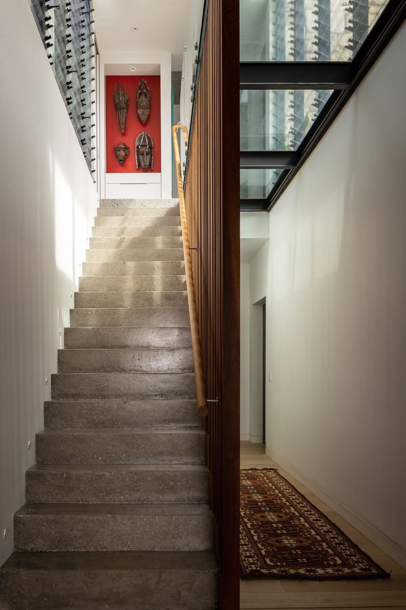 Concrete stair with a timber handrail rising to the upper level at Bay House