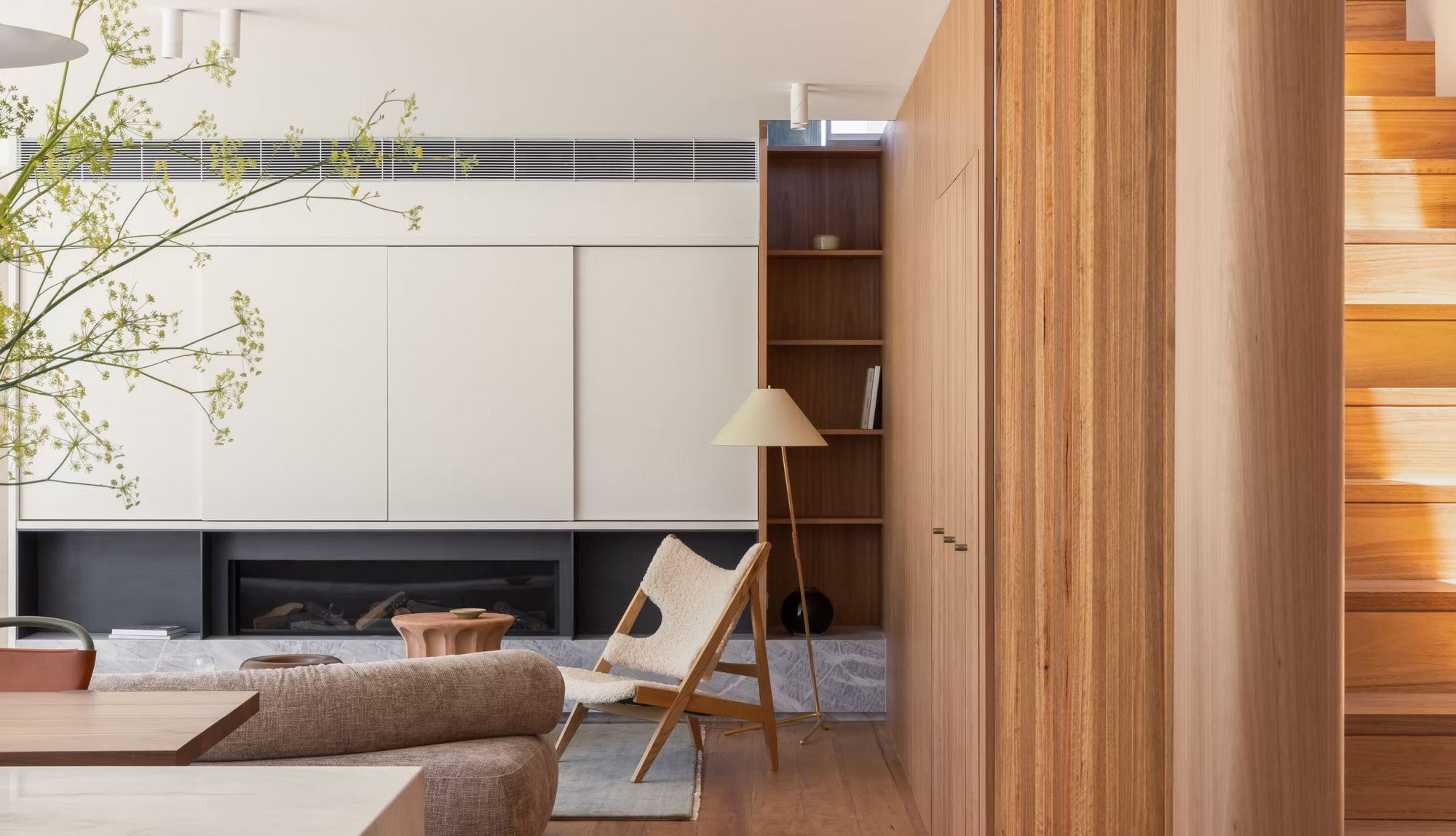 Casa Risata living room with white joinery, a timber wall and a fireplace