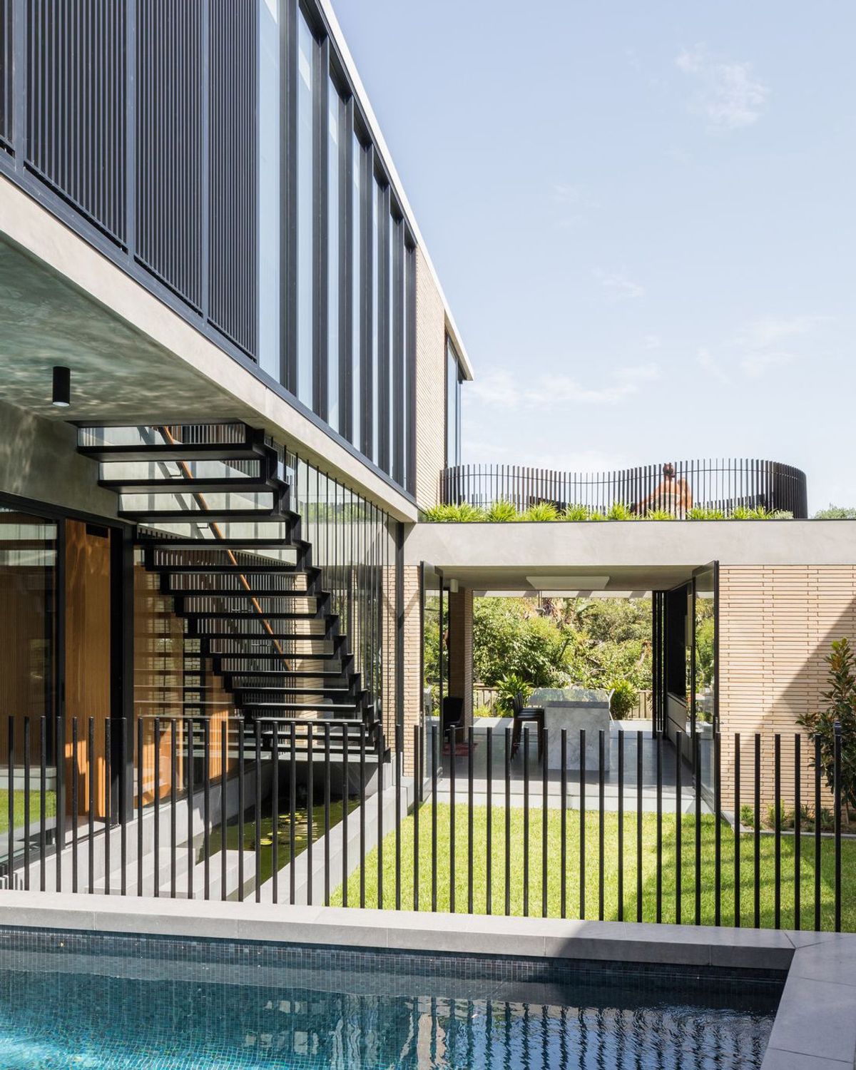 Balmoral House courtyard with a pool, open steel stair and an upper level of dark battens