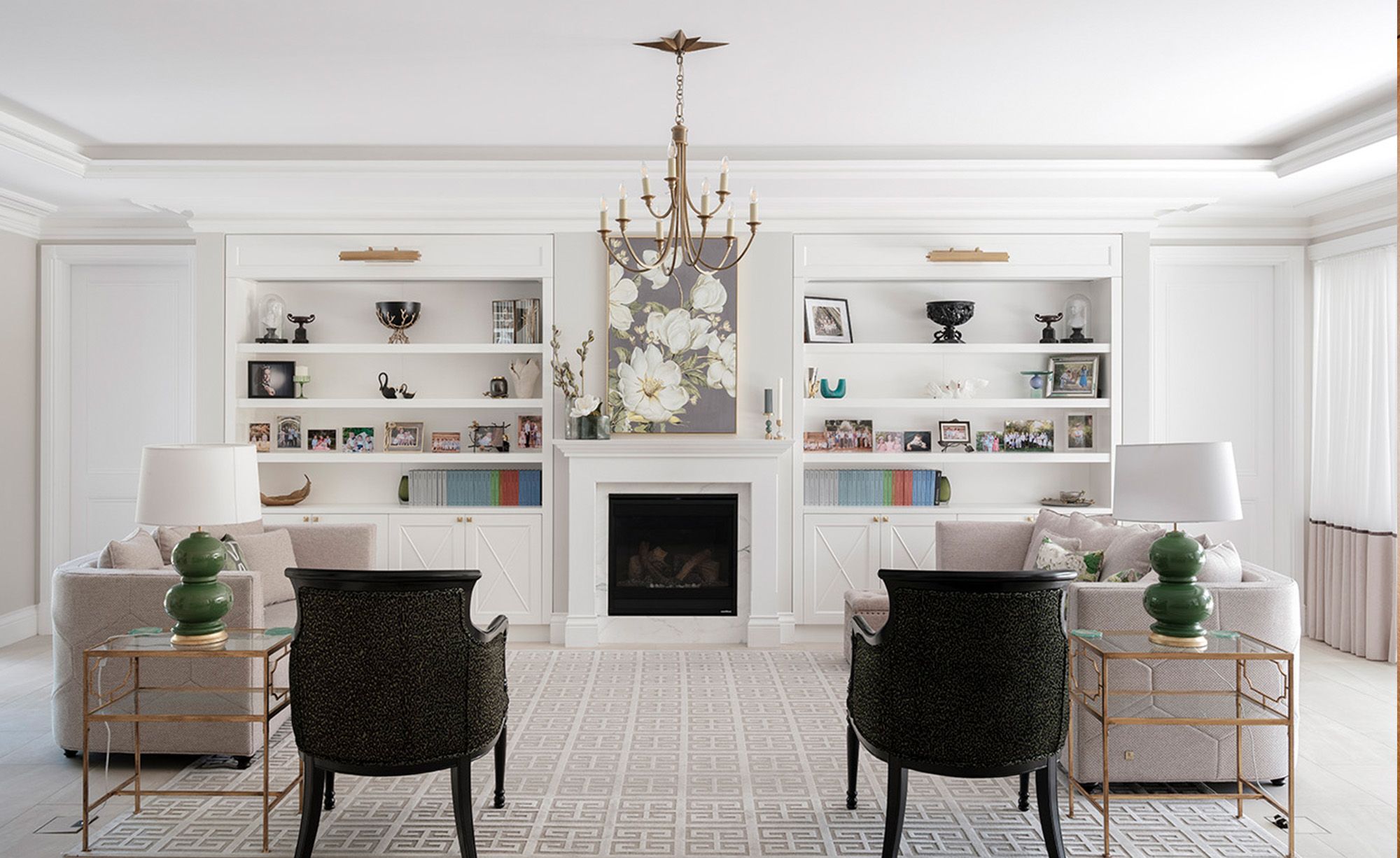 Living room with a fireplace, built in shelving and armchairs