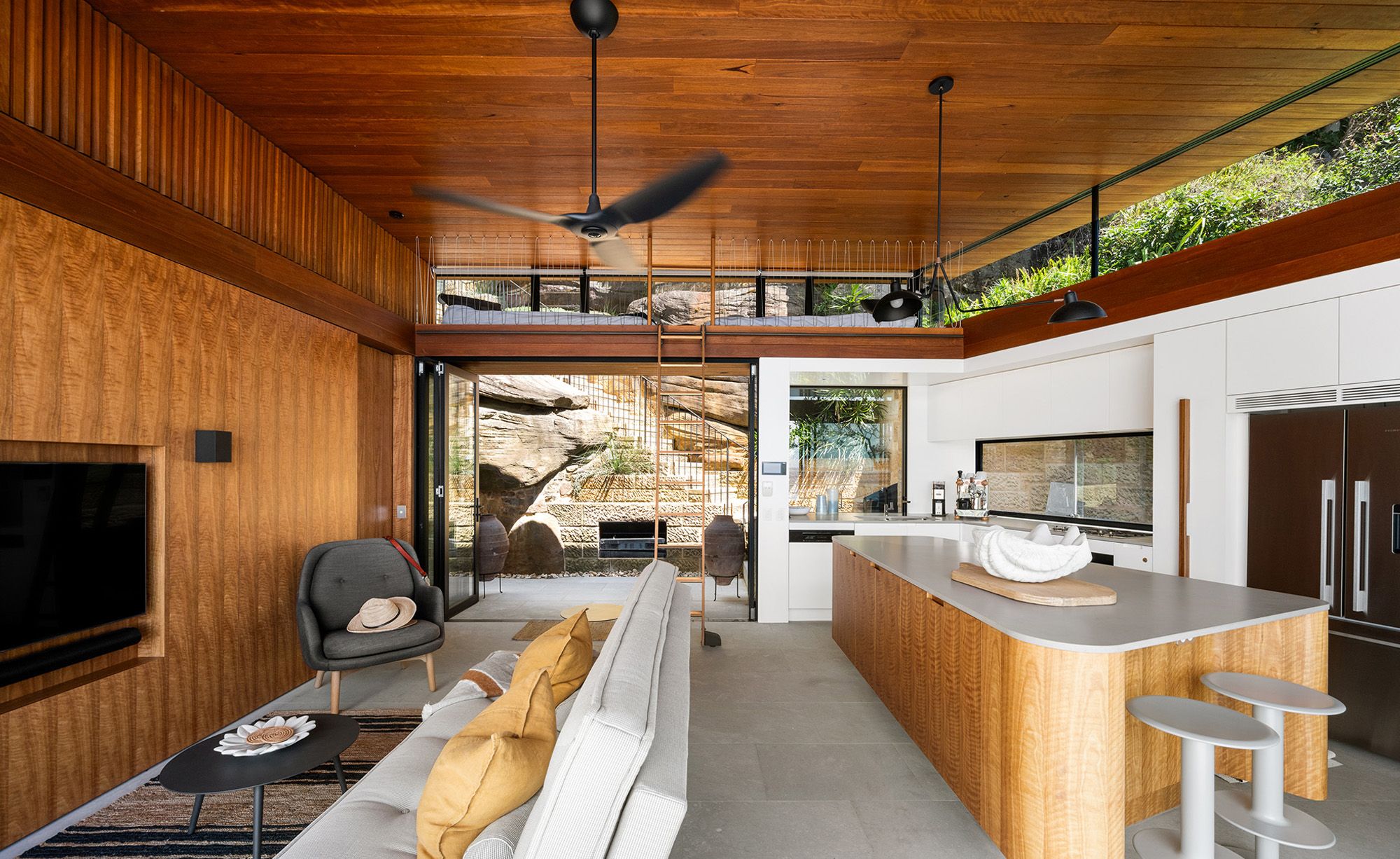 Kitchen and living room with a timber ceiling opening to the deck