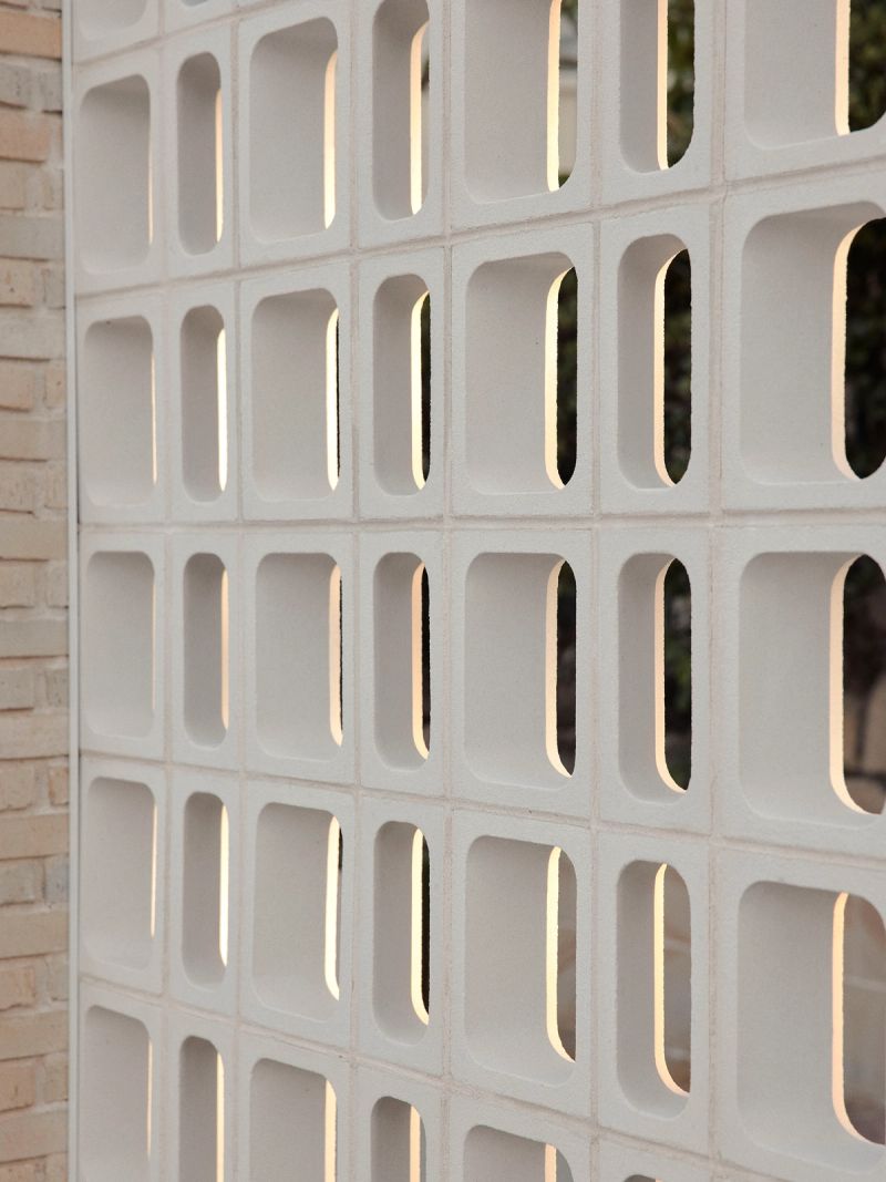White breeze block screen wall with light showing through the openings
