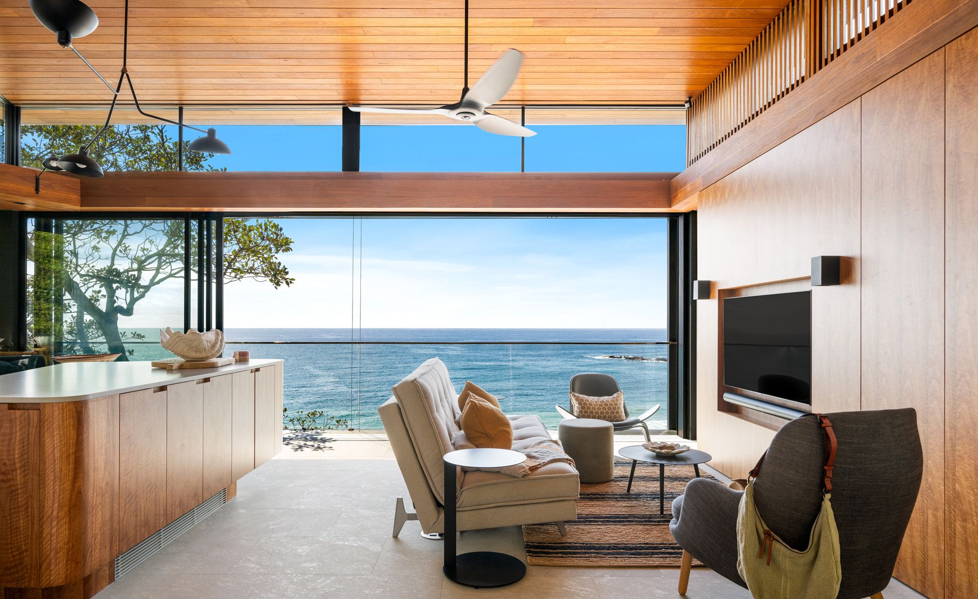 Living room with a timber ceiling and cabinetry opening to the ocean view