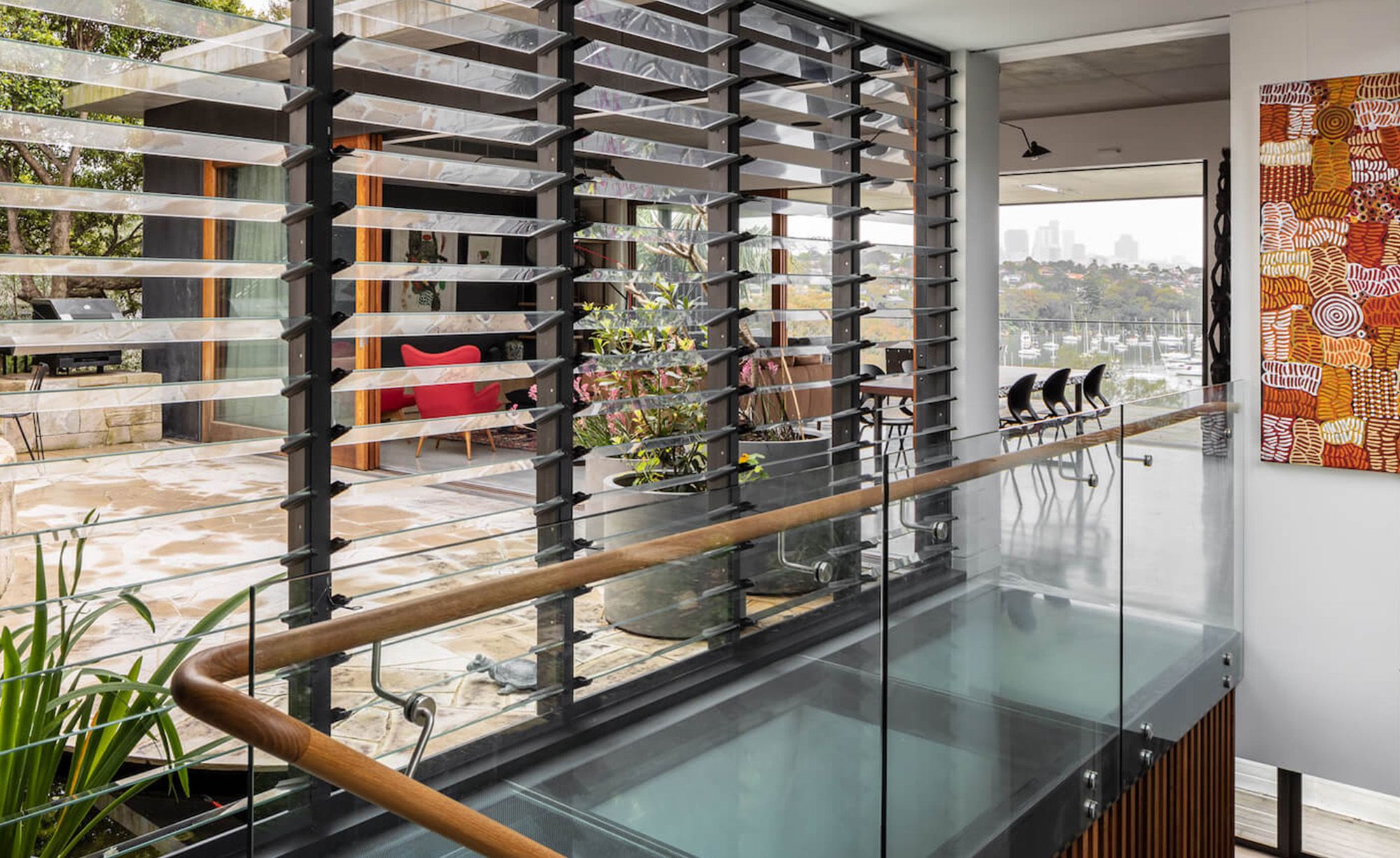 Timber handrail and glass floor at the top of the stair, with louvre windows