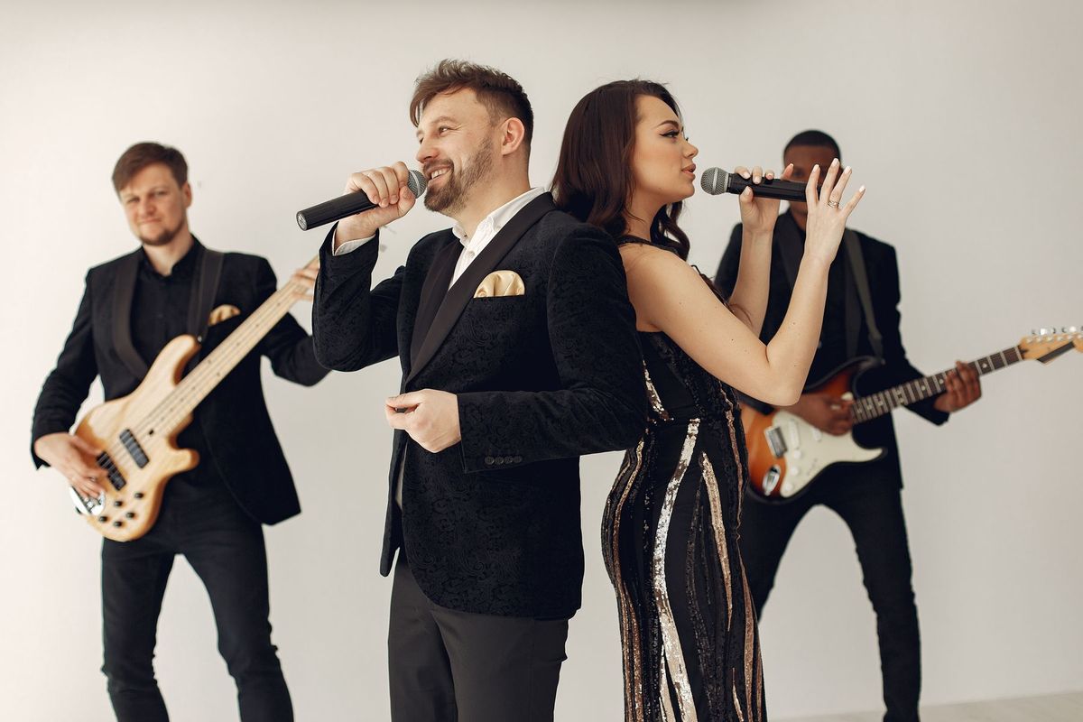 Chanteurs et musiciens en action sur scène lors d'une performance dynamique