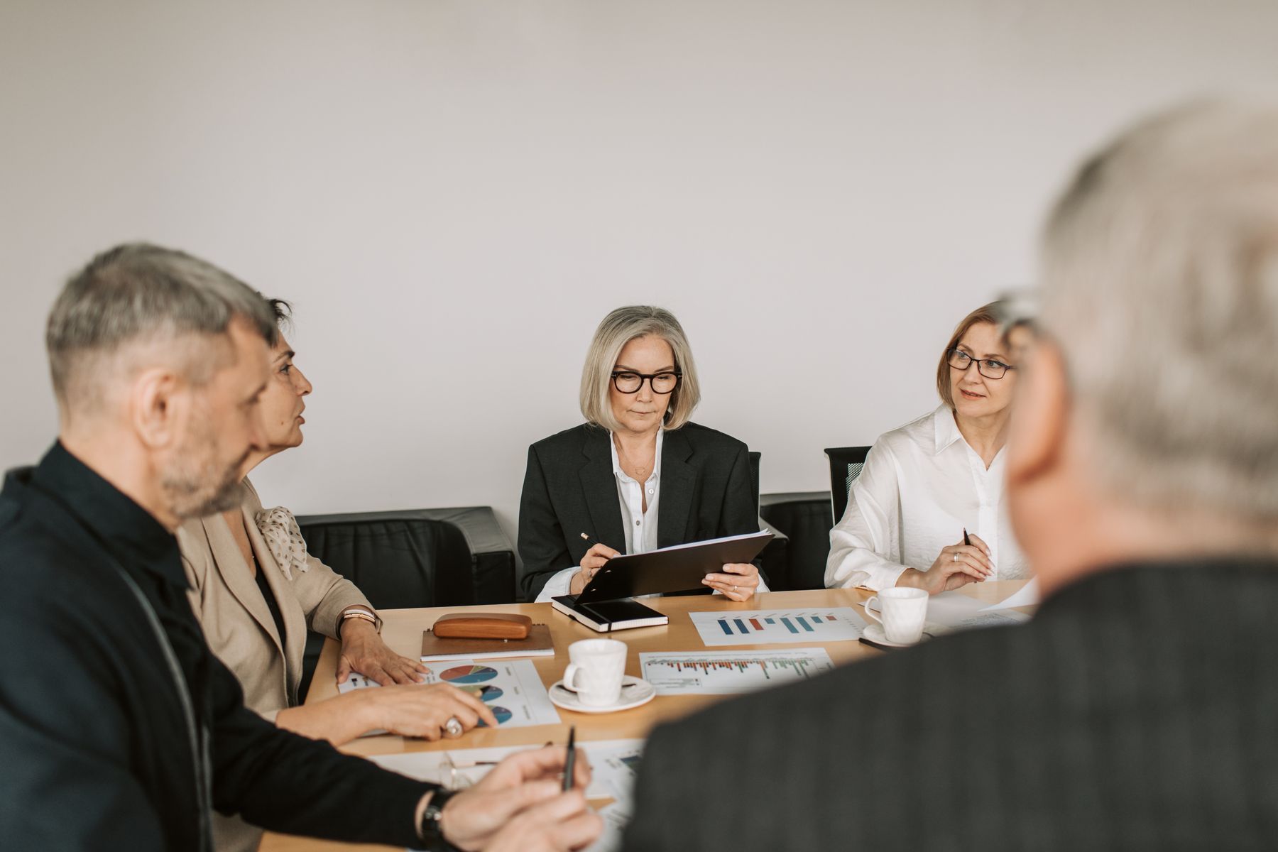 Dirigeants en costume autour d'une table de réunion dans un bureau contemporain