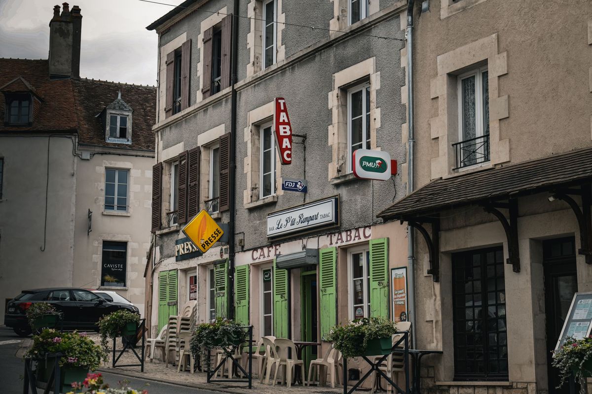 Devanture d'un petit café-tabac traditionnel dans une rue pavée de village français