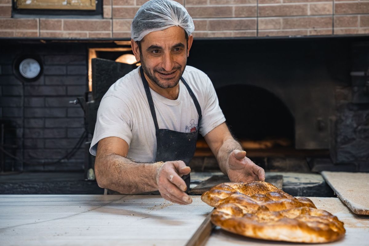 Boulanger façonnant une pâte à pain sur son plan de travail en boulangerie