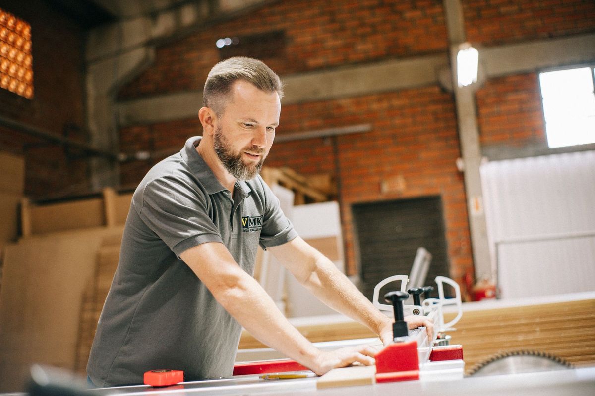 Charpentier effectuant une coupe précise au bois avec une scie circulaire dans son atelier