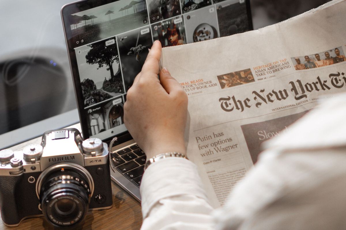 Journaliste consultant ses sources sur papier et numérique à son poste de travail