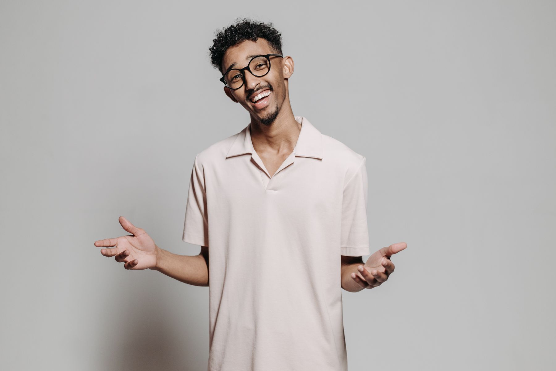 Jeune professionnel souriant portant des lunettes devant un fond neutre