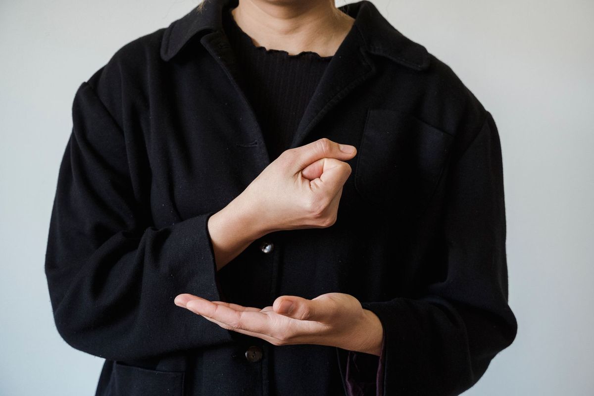 Interprète en langue des signes effectuant une démonstration gestuelle avec les mains