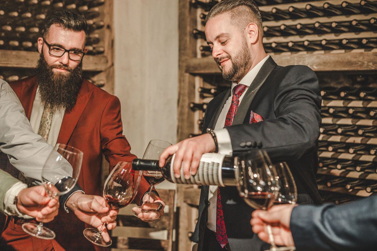 Deux sommeliers dégustent et échangent sur un vin en cave
