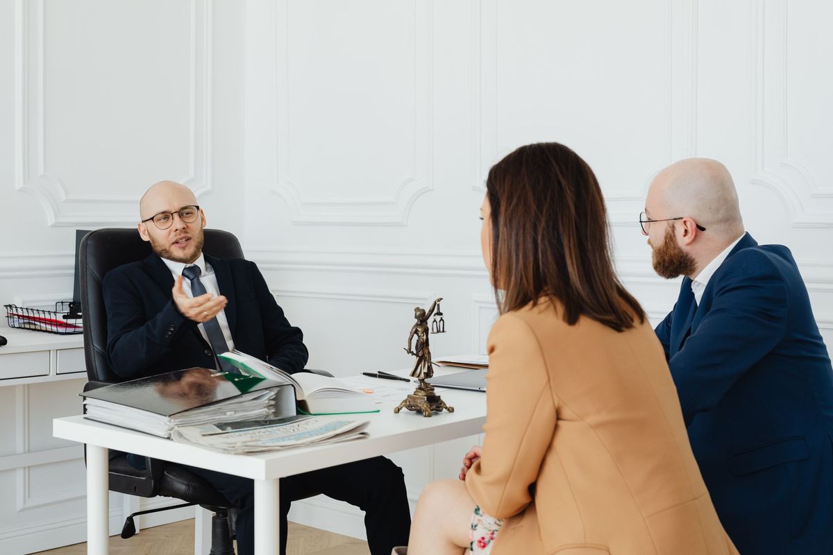 Trois professionnels en costume discutent autour d'une table de réunion dans un bureau moderne