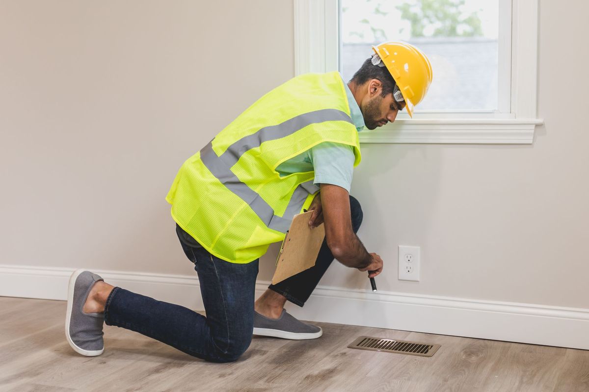 Diagnostiqueur inspectant une ventilation intérieure avec ses outils professionnels