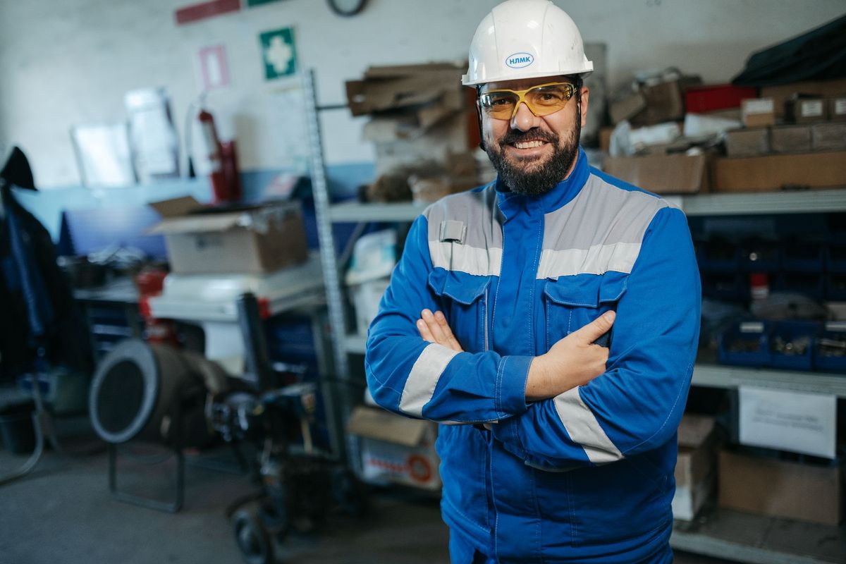 Ouvrier en uniforme bleu et casque de sécurité dans un atelier industriel