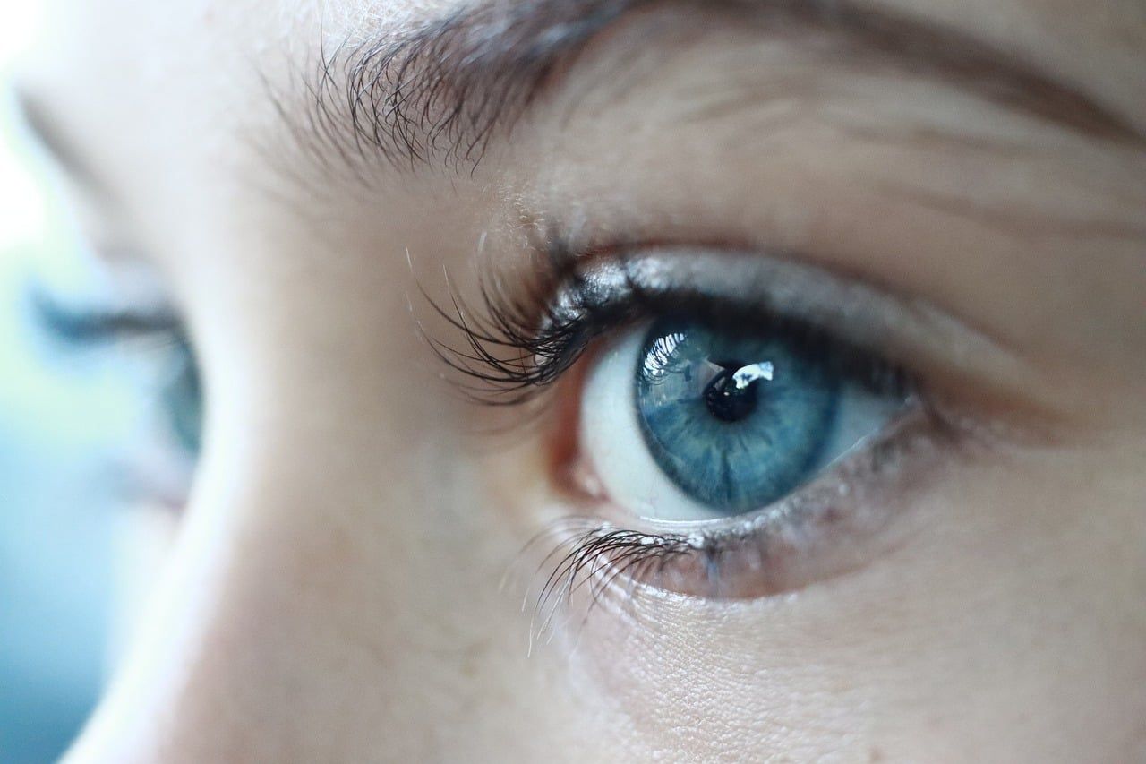 Gros plan sur l'œil d'une femme avec un regard intense et une peau lumineuse