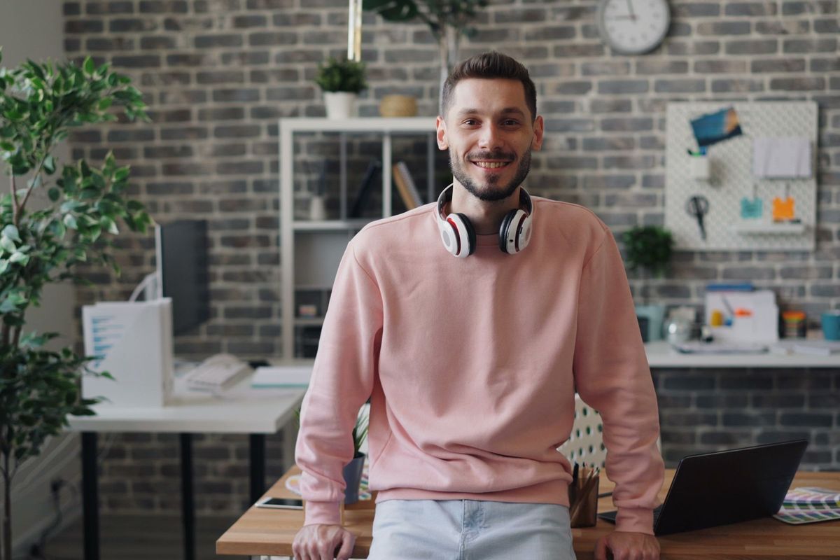 Professionnel en écouteurs souriant dans un bureau moderne et lumineux