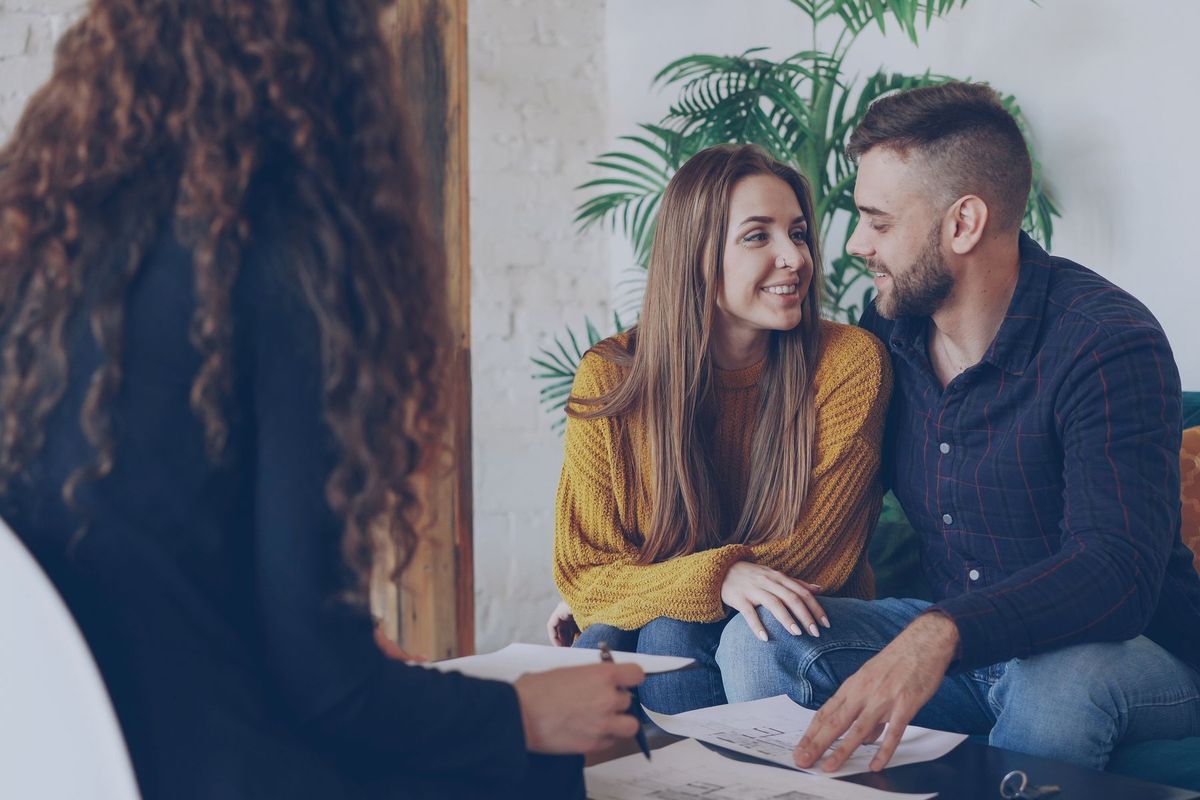 Couple signant un document avec un conseiller dans un bureau professionnel