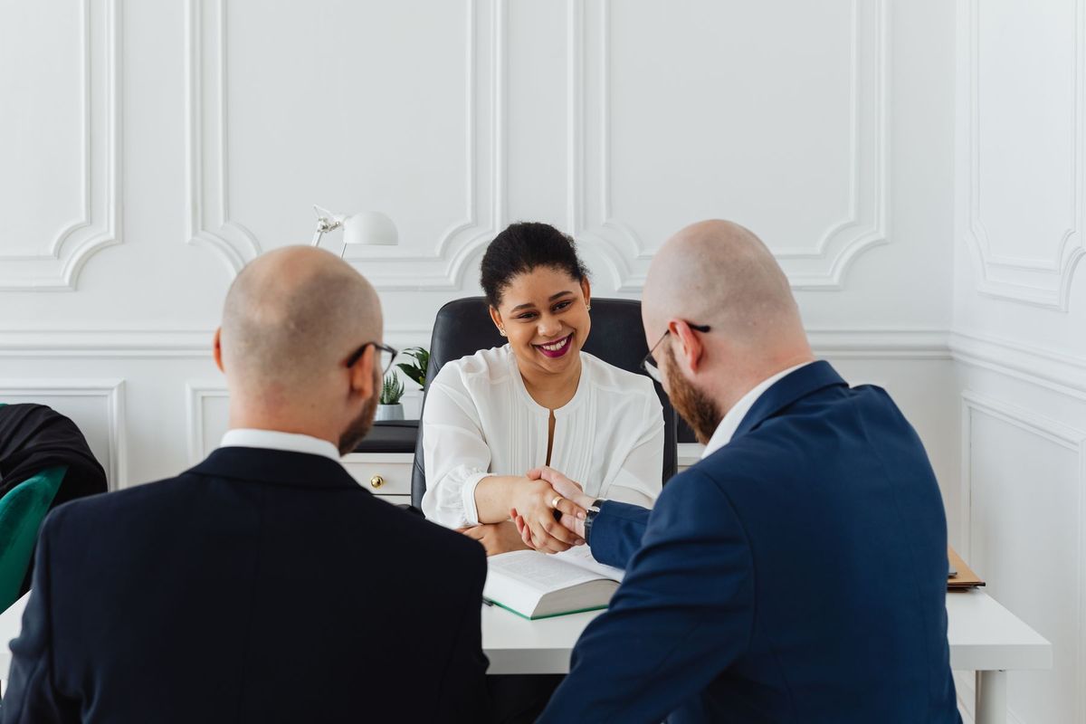 Deux dirigeants se serrent la main lors d'une réunion professionnelle autour d'une table