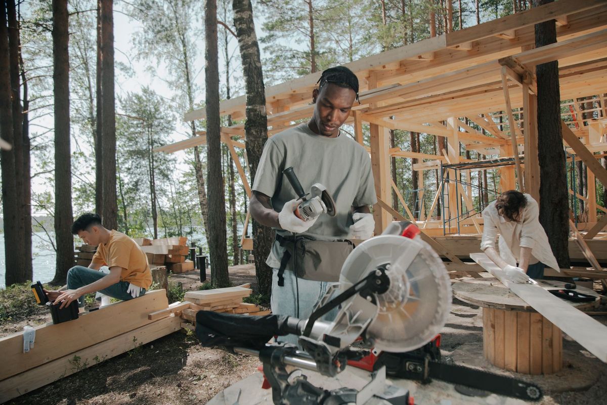 Ouvriers assemblant une charpente en bois sur un chantier en forêt