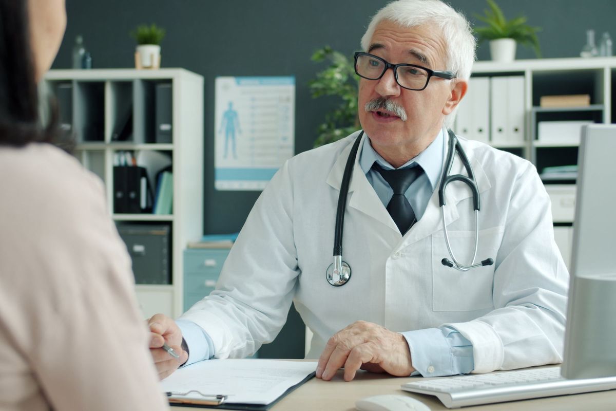 Médecin écoutant attentivement son patient lors d'une consultation en cabinet
