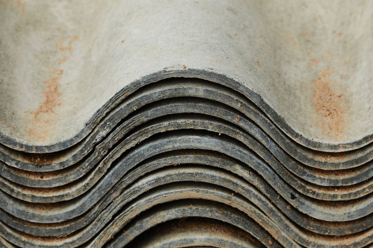 Tuiles de toiture métallique ondulée empilées montrant l'usure et la corrosion