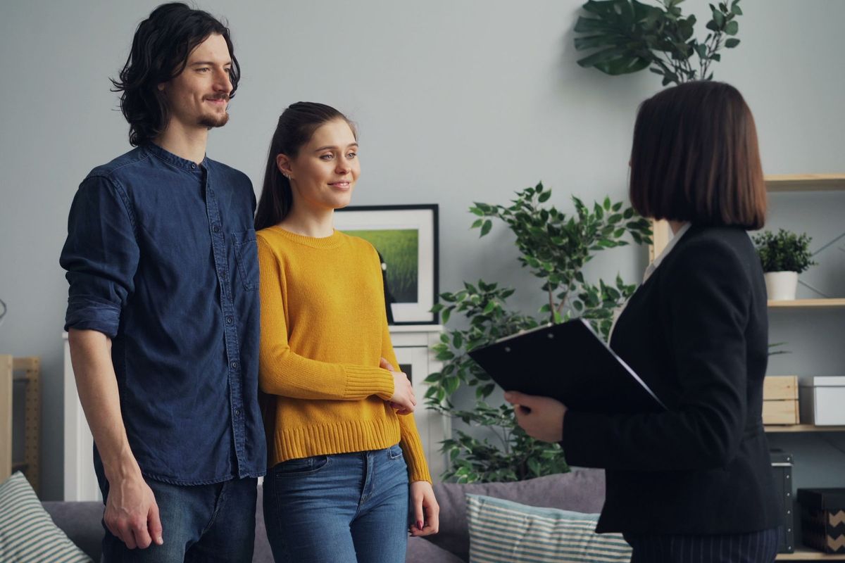 Couple et agent immobilier discutent dans un salon moderne et lumineux