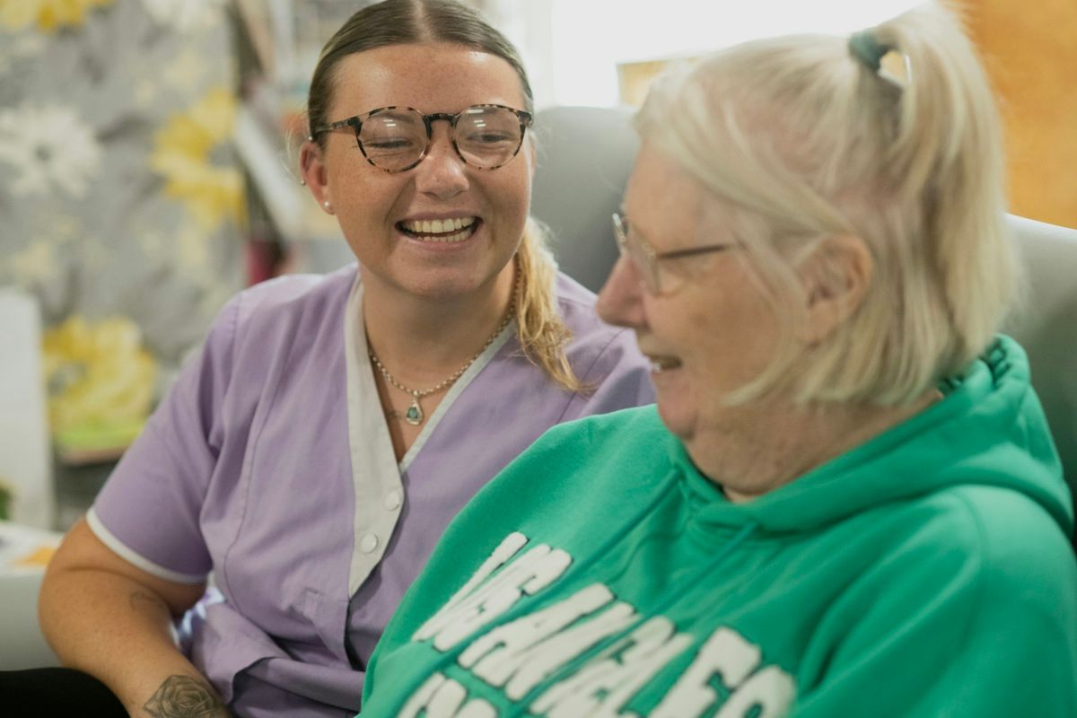 Deux femmes souriantes ensemble dans un intérieur chaleureux