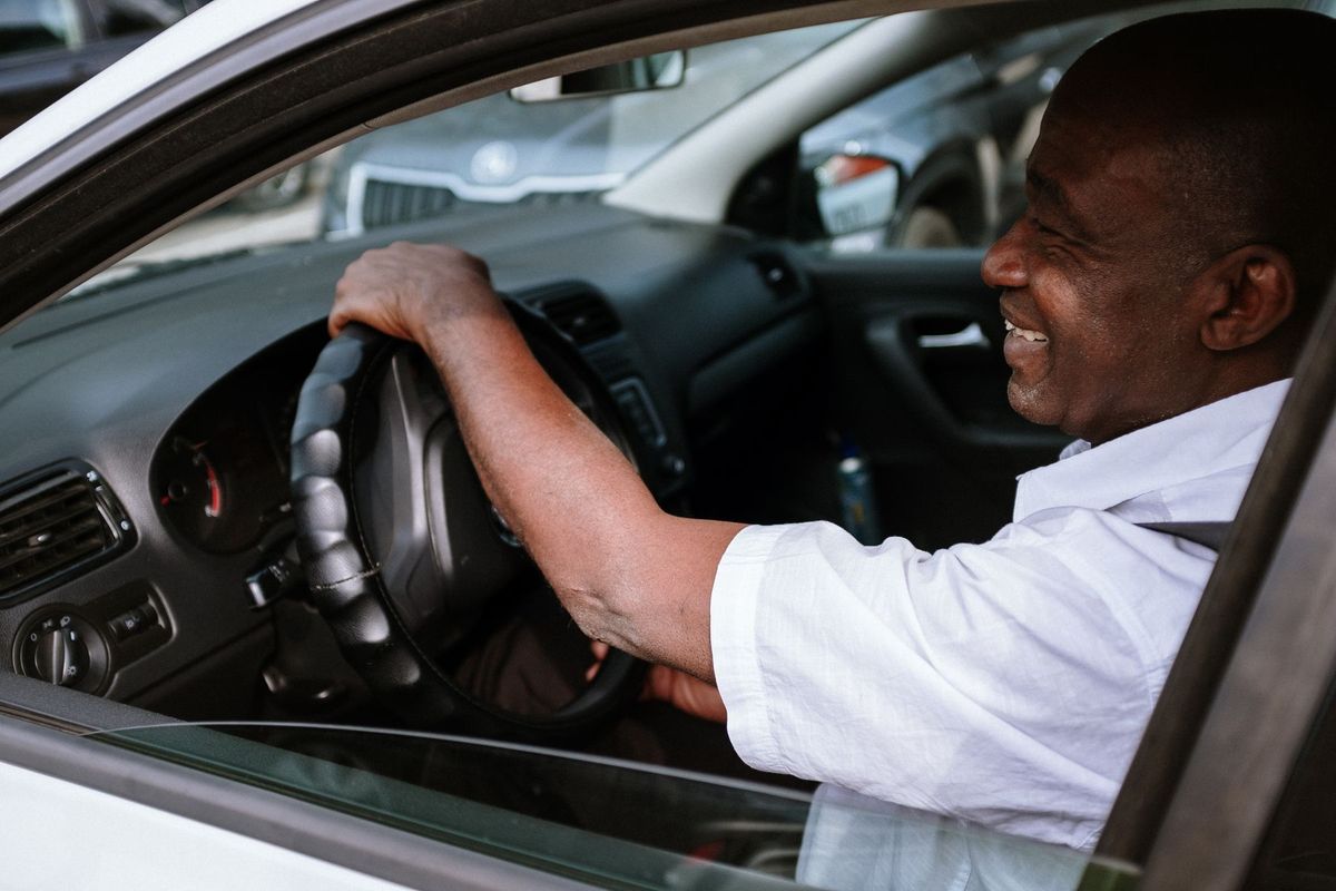 Chauffeur souriant au volant de son véhicule lors d'une journée de travail
