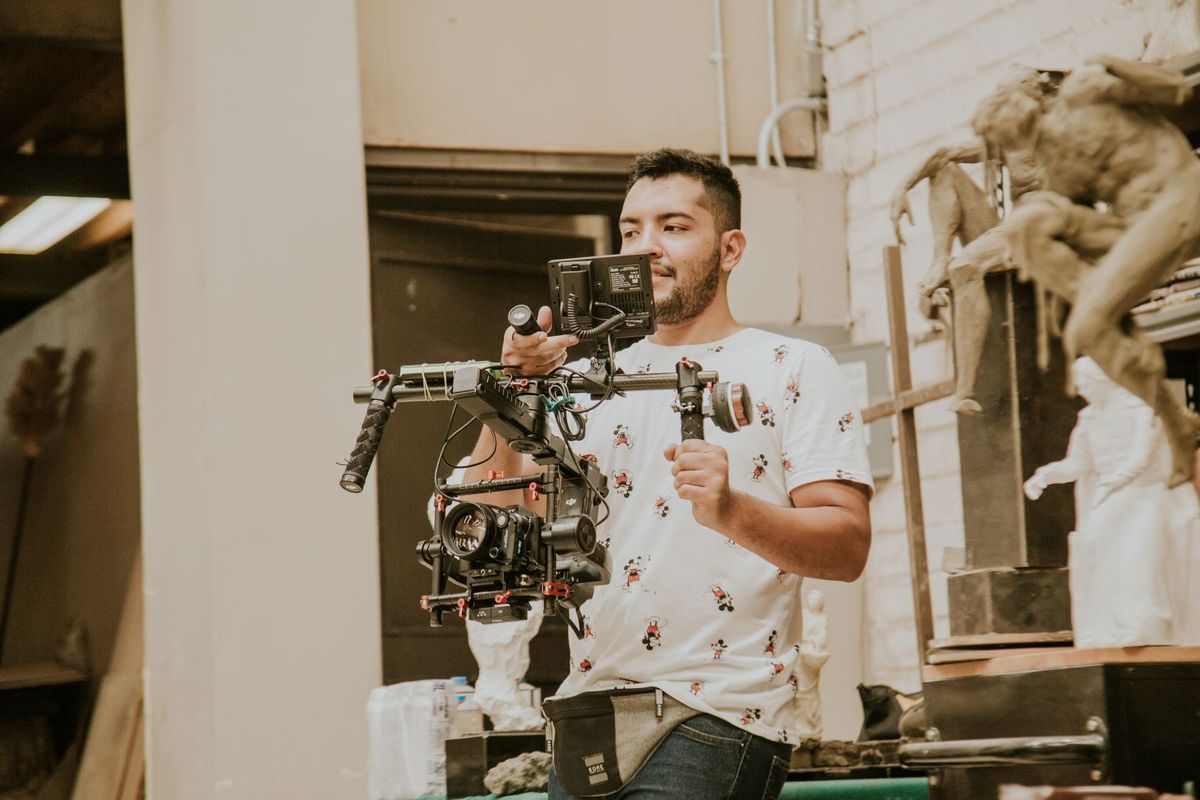 Vidéaste manipulant un steadicam pour filmer une scène en intérieur