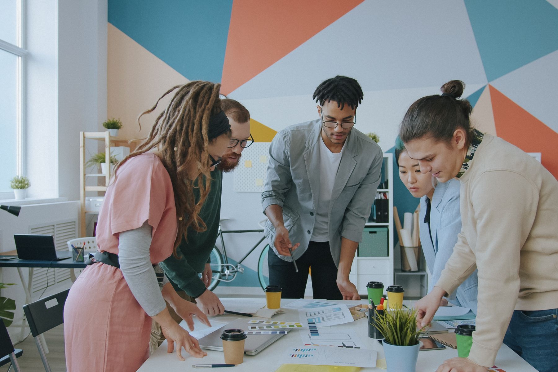 Équipe d'entrepreneurs étudiant ensemble des plans de financement autour d'une table de réunion